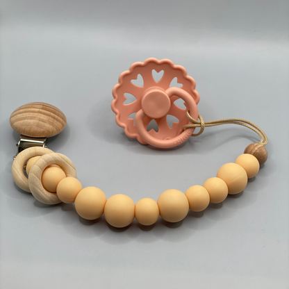 Teething ring with wooden beads and clip on a gray background